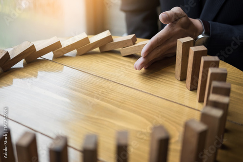 Fotomural businessman hand stop dominoes continuous toppled or risk with copyspace