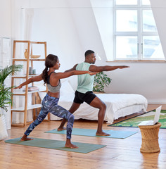 Wall Mural - African couple exercising doing yoga together at home