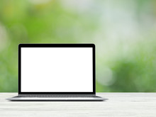 Laptop With Blank Screen Placed On White Wooden Table In Blurred Green Nature Background.