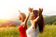 Portrait of two happy young woman on a viewpoint wit her arms outstretched.