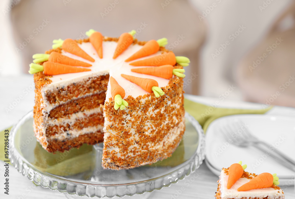 Stand with delicious sliced carrot cake on blurred background