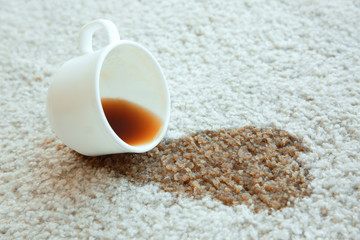 Wall Mural - Cup of coffee spilled on white carpet, close up