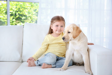 Wall Mural - Cute child with Labrador Retriever on sofa