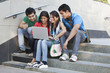 © IndiaPix - Group of happy friends surfing net while sitting on steps