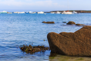 rock and seascape with boats