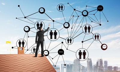businessman on house roof presenting networking and connection concept. mixed media