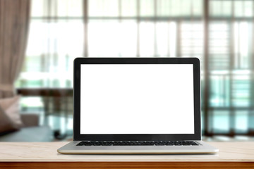 Laptop on table against bokeh lights living room background, blank screen for graphic display montage.