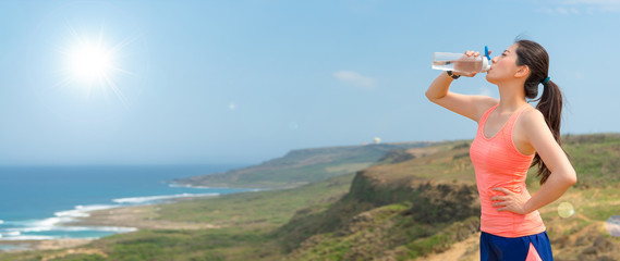 Wall Mural - athlete jogger holding the bottle drinking water