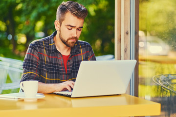 A man using laptop in a cafe.