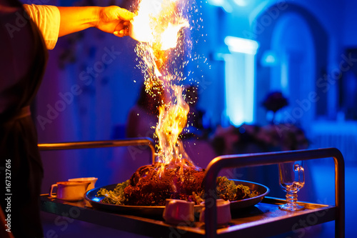 Zdjęcie XXL Szef kuchni, wlewając alkohol do patelni z ogniem
