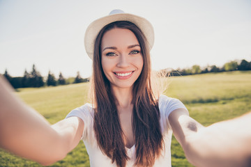 Sticker - Carefree and happy, selfie time. Cute young girl, making photo on a camera of her pda in an open air in spring park. She is wearing casual summer outfit, hat