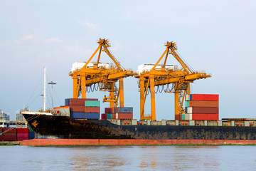 Shipping port, Container Cargo freight ship with working crane loading bridge in shipyard at dusk for Logistic Import Export in Bangkok (With blur trademark, brand, logo.) 