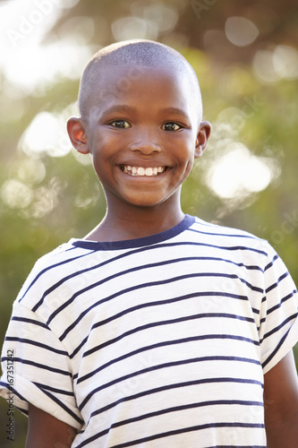 Smiling young black boy looking away from camera outdoors - Buy this ...