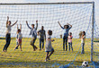 © Monkey Business - Two families playing football in park celebrating a goal