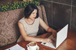 © hdesert - Young caucasian businesswoman with laptop and notebook. Woman in cafe