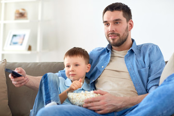 Wall Mural - father and son with popcorn watching tv at home