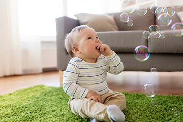 baby boy playing with soap bubbles at home