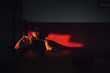 © Boris Jovanovic/Stocksy - Woman sitting on the red couch lit with afternoon sun