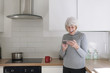 © Lee Avison Photography/Stocksy - happy senior woman in her kitchen using an electronic mobile device