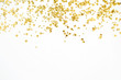 Golden confetti tinsel on white background. Flat lay, top view. Minimal background.