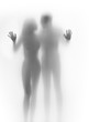Lover couple body silhouette and hands touching a glass surface
