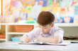 © sirikorn - Portrait of happy asian cute child doing homework with smile face .