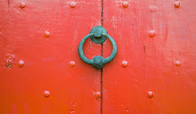 Background Texture Weathered Wooden Red Door Panel With Iron Door Knocker And Nail Decoration