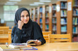 © kanchitdon - Muslim woman reading book at the library.