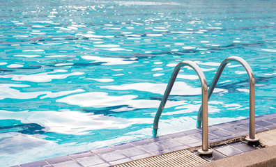 Grab bars ladder in the blue swimming pool