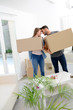 © W PRODUCTION - happy young couple student roommate packing boxes and moving furnitures during their move into new home flat apartment