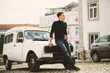 © Annatamila - Young handsome man staying on the hood of  vintage car in European city