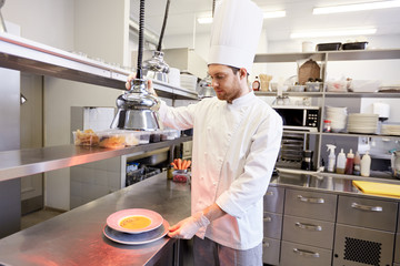 happy male chef cooking food at restaurant kitchen