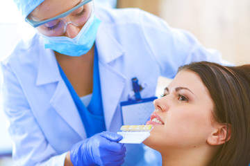 Wall Mural - Woman dentist working at her patients teeth