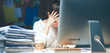 © shefkate - A portrait of a businesswoman staying late in the office with a pile of work to do.