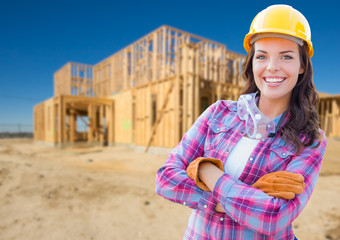 Young Attractive Female Construction Worker Wearing Gloves, Hard Hat and Protective Goggles At Construction Site