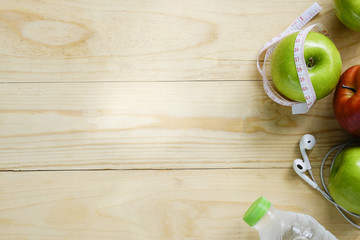 Healthy lifestyle concept. Green and Red Apples,water bottles and stop watch on wooden table copy space for add your text or product.