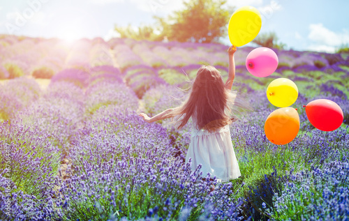 Fotografía Pretty child girl runs with colorful balloons in lavender field summer freedom c