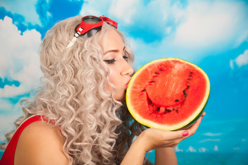 beautiful blonde young woman wearing red swim suit with watermelon on the beach