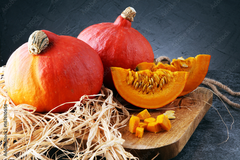Pumpkin slices with seeds and autumn hokkaido pumpkins - obrazy, fototapety, plakaty 