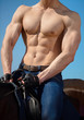 Very hot sexy muscular torso of a male cowboy rider on horseback.