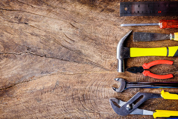 Top view of Working construction tools,wrench,hammer,screwdriver,plier,electric drill,tape measure,machinist square on wooden rustic background. flat lay design