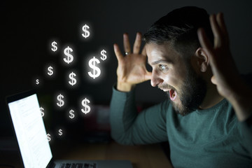 man in front of the computer with raised hands being happy. business and money concept. dollars flyi