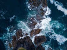 Aerial Shot Of Waves Hitting Rocks On Ocean Coast