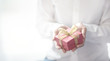 © oatawa - Closeup, Woman hand holding red gift box with copy space background, female giving gift, New year holidays and greeting season concept.