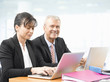 © sepy - Business team at work. Shot of an senior investment advisor businessman and his female financial assistant analyzing financial data while working on laptops.