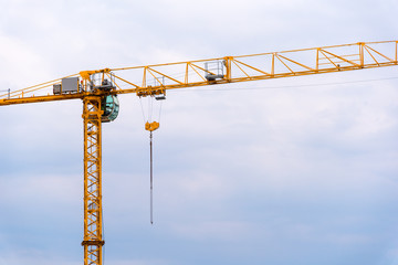 big yellow crane on a blue cloudy sky