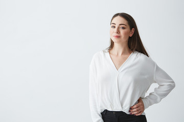 Portrait of young beautiful brunette businesswoman smiling looking at camera posing over white background.