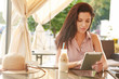 Beautiful young woman with tablet and coffee. Woman in a cafe
