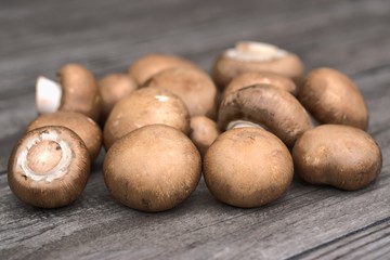 Fresh brown mushrooms on a wooden background.