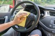 © vchalup - Man is cleaning car wheel and dashboard with microfiber cloth.